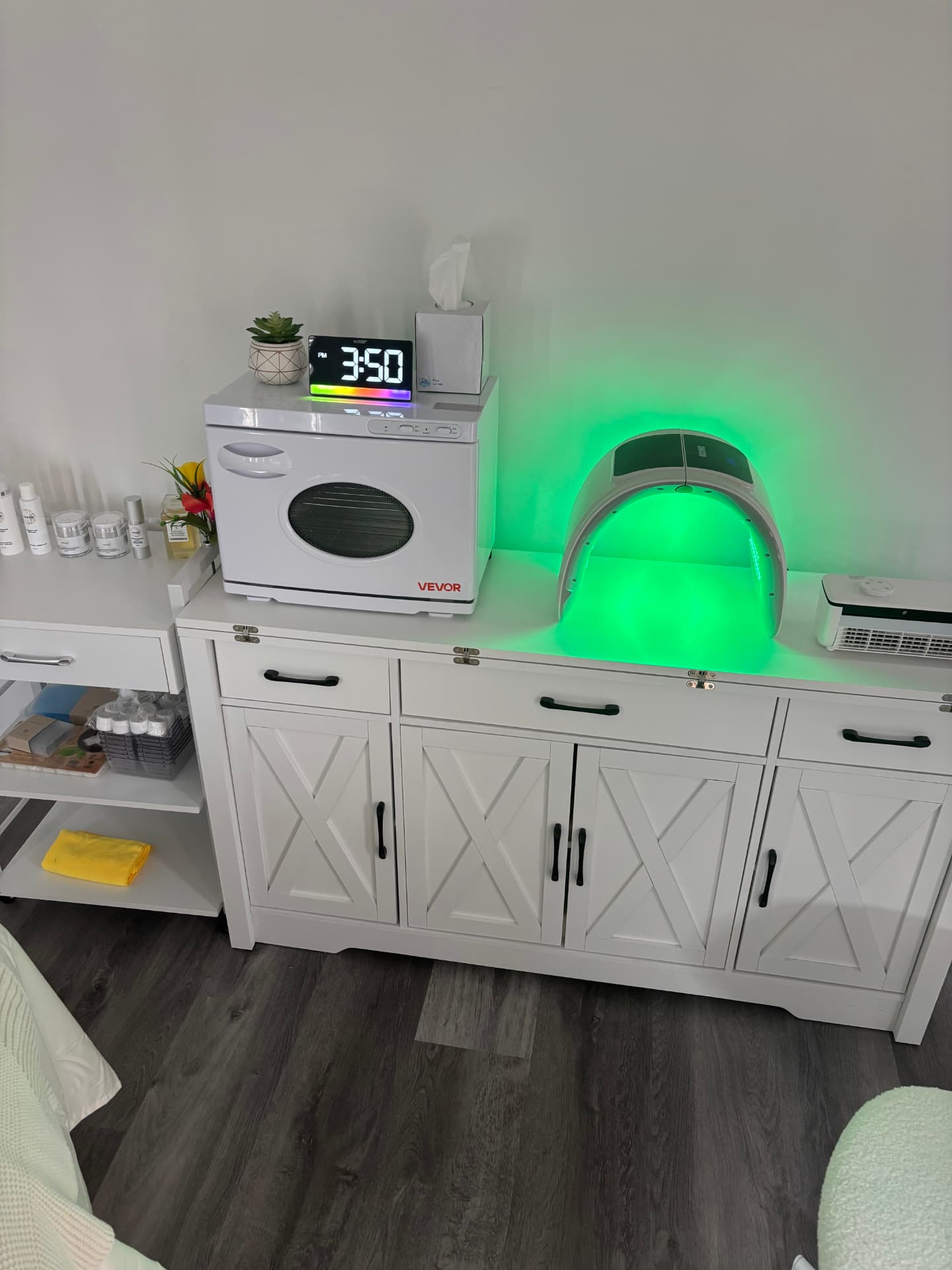 Esthetics station at Vital Bloom with a towel warmer and LED light therapy panel.